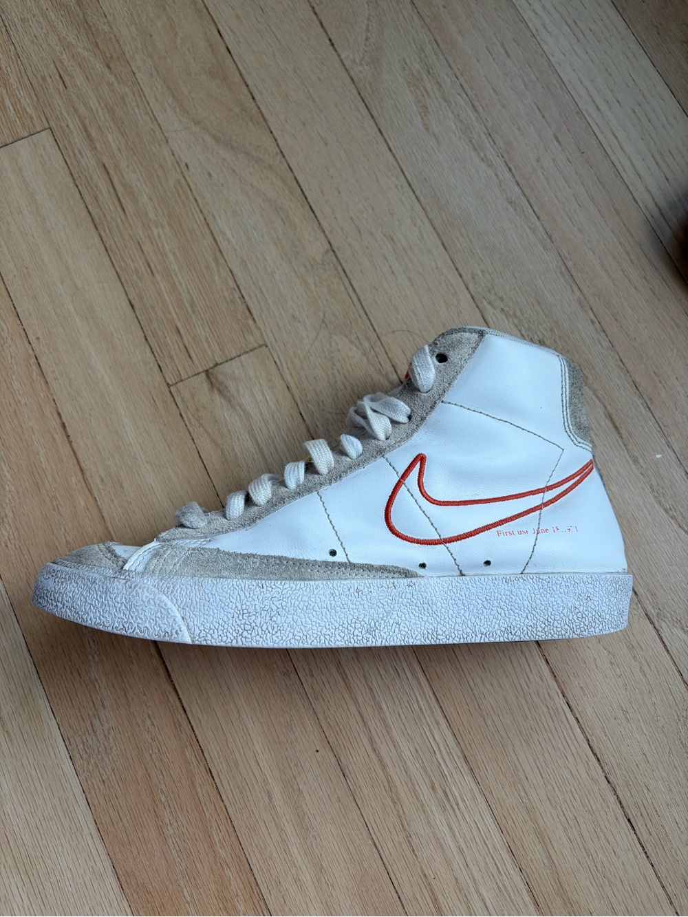 Nike White High-Top Sneaker with Orange-Red Swoosh